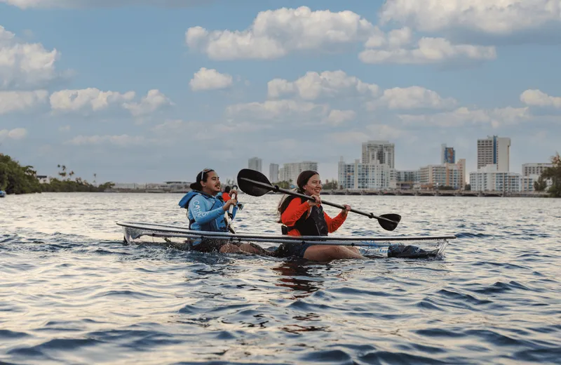 Paddler in a transparent clear-bottom glass kayak over seagrass on a Condado Lagoon kayak nature tour in San Juan, Puerto Rico